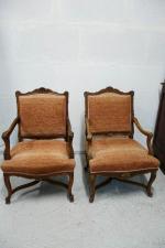 Deux fauteuils en noyer mouluré et sculpté à décor de...